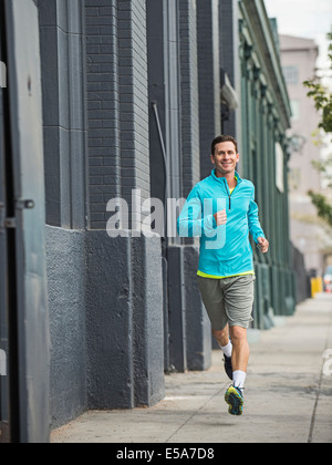 Caucasian man running on city street Banque D'Images