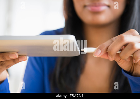 Mixed Race woman branchant digital tablet Banque D'Images