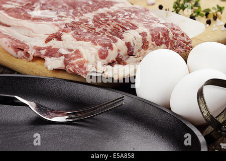 Du boeuf cru bacon avec des oeufs frais et des fines herbes. Banque D'Images