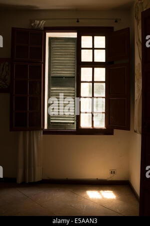 Point de vue d'un intérieur (prix) d'une fenêtre à volets volets internes, externes, l'un ouvert, fermé d'Obturation extérieure de la lumière sur le sol. Banque D'Images