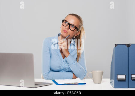 Thoughtful businesswoman sitting at office, Debica, Pologne Banque D'Images