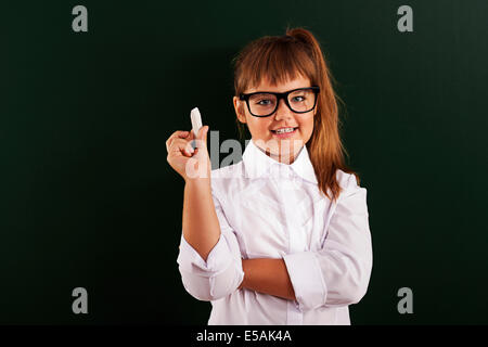 Cute little girl dans les verres avec de la craie en main, Debica, Pologne. Banque D'Images