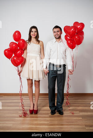 Smiling couple holding hands with balloons Debica, Pologne Banque D'Images