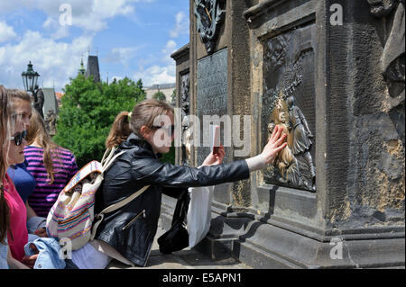 Toucher le bas-relief à la base de la statue de St Jean Napomuk sur le pont Charles, semble-t-il, apporte à la bonne chance, Prague. Banque D'Images