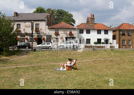 Wimbledon London UK. 26 juillet 2014. Un couple se détendre au soleil sur les chaises longues à l'extérieur d'un pub à Wimbledon : Crédit amer ghazzal/Alamy Live News Banque D'Images