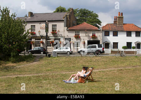 Wimbledon London UK. 26 juillet 2014. Un couple se détendre au soleil sur les chaises longues à l'extérieur d'un pub à Wimbledon : Crédit amer ghazzal/Alamy Live News Banque D'Images
