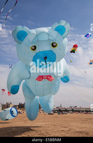 Lytham St Annes, Blackpool, 26 juillet, 2014. St Anne's Kite Festival avec Oscar - le plus grand ours une Peter Lynn, un cerf-volant gonflable géant cerf-volant dans le ciel au-dessus de St Annes de mer. La plage est inondé de couleur comme énorme fabuleux grand afficheur kites prenez l'air sur la plage adjacente à l'embarcadère. Banque D'Images