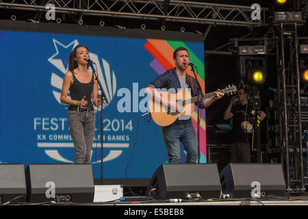 L'homme et de la femme sur scène, chantant avec une guitare acoustique. Festival du West End, Glasgow, Écosse, Royaume-Uni, 2014 Banque D'Images