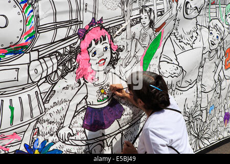 Denver Colorado USA - 26 juillet 2014. Une femme peint une bannière à l'extérieur de la gare Union pendant l'ouverture des festivités. La gare Union est ouverte au public pour la première fois depuis la rénovation a commencé en 2008. Credit : Ed Endicott/Alamy Live News Banque D'Images