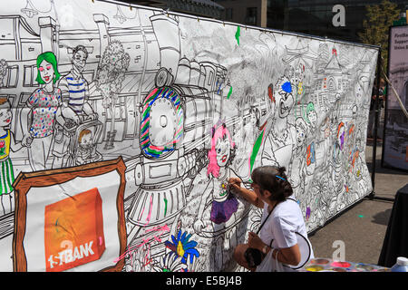 Denver Colorado USA - 26 juillet 2014. Une femme peint une bannière à l'extérieur de la gare Union pendant l'ouverture des festivités. La gare Union est ouverte au public pour la première fois depuis la rénovation a commencé en 2008. Credit : Ed Endicott/Alamy Live News Banque D'Images