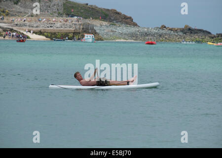 Man relaxing on paddle-board à St Ives en Cornouailles Banque D'Images