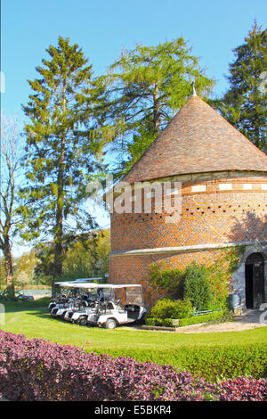 Des voiturettes de golf près de l'ancien bâtiment de club de golf à Saint Saens, France Banque D'Images