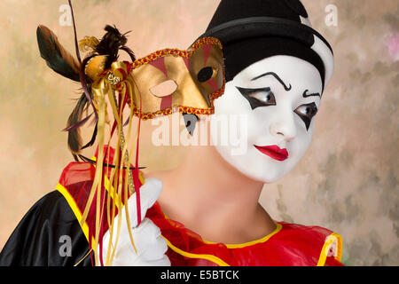 Jeune femme pierrot tenant un masque de Venise en cuir Banque D'Images