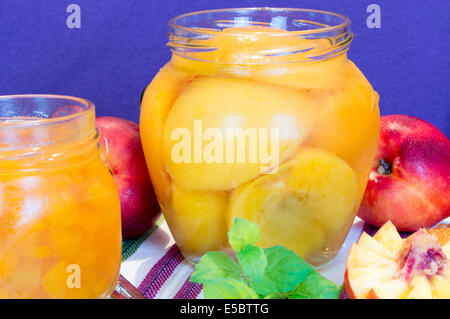 Pêches fraîches et avec de la confiture de pêches dans un bocal. Banque D'Images