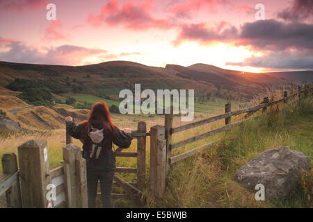 Peak District, Derbyshire, Royaume-Uni. 27 juillet 2014. Un lève-tôt s'arrête sur les pentes de Mam Tor près de Castleton comme peachy lever du soleil illumine les nuages sur la vallée de l'espoir ferma dans le parc national de Peak District sur une amende, breezy matin. La récente beau temps devrait se poursuivre avec ciel variable, de douches et de plus longues durées de pluie touchant certaines parties du Royaume-Uni pendant la semaine les parcs nationaux qui débute demain (lundi 28 juillet) et s'étend jusqu'à Sun 3 août. Le Peak District est devenu le premier parc national en 1951. Credit : Matthew Taylor/Alamy Live News Banque D'Images