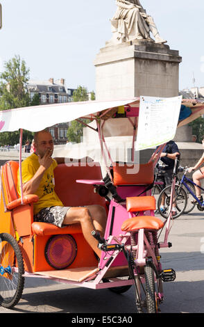 Paris, France. 27 juillet, 2014. Chauffeur en attente pour les clients porte un Tour de France t-shirt. Le dimanche 27 juillet 2014 les champs Elisées et Rue de Rivoli ont été fermées à la circulation en raison de l'arrivée du Tour de France. Partisans attendaient depuis tôt le matin pour avoir la meilleure place pour voir l'arrivée des athlètes. Les spectateurs ont connu, parfois quelques difficultés pour obtenir leur place parce que des barricades. Credit : Cecilia Colussi/Alamy Live News Banque D'Images