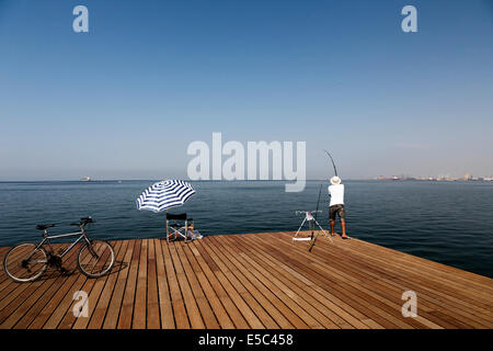 Un pêcheur avec sa ligne sur le front de mer de Thessalonique, Grèce. Banque D'Images