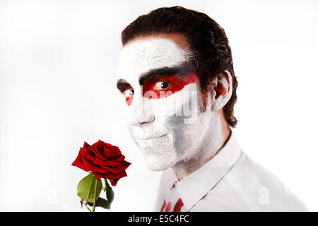 L'homme blanc avec mascara et bloody shirt détient rose rouge Banque D'Images