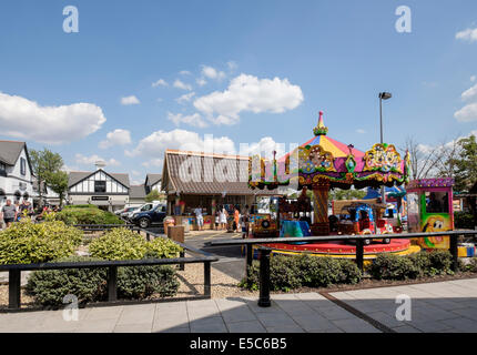 Les enfants merry-go-round carousel au Cheshire Oaks Designer shopping outlet. Ellesmere Port, Cheshire, Angleterre, Royaume-Uni, Angleterre Banque D'Images