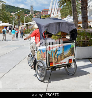 Couple riding dans un pousse-pousse le long de la promenade du bord de mer dans le centre-ville de Split sur une visite guidée Banque D'Images