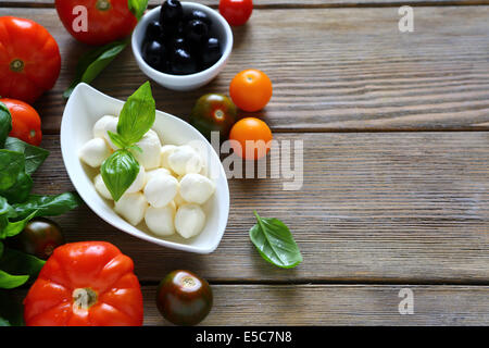 Boules de mozzarella et d'autres aliments sur fond de bois Banque D'Images