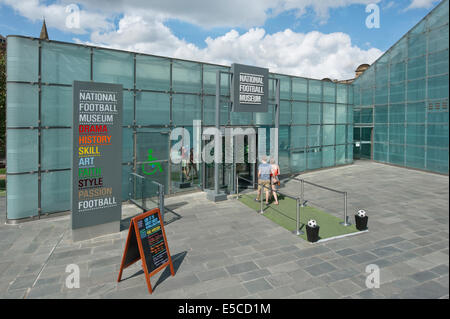 Un jeune couple entrez le Musée National du Football (Urbis) officiellement à Manchester le long d'une journée d'été. Banque D'Images