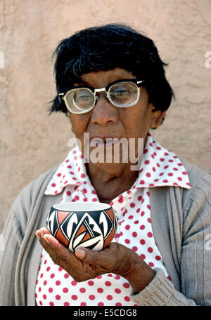 Une vieille femme amérindienne est titulaire d'un morceau de poterie prisé qu'elle a la main en Acoma Pueblo, une communauté indienne à New Mexico, USA. Banque D'Images