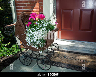 Images antiques jardinière victorienne de chariot de bébé avec des fleurs de géranium et de Lobelia à la porte d'une maison de fleurs, Lancaster County, Pennsylvanie, USA, Banque D'Images