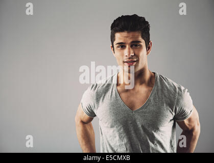 Portrait of young hispanic male fashion model posing contre l'arrière-plan gris avec copie espace. Banque D'Images