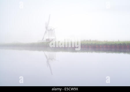 Moulin reflète dans River et un épais brouillard, Pays-Bas Banque D'Images