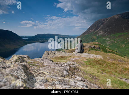 Homme assis sur Rannerdale Knotts sommet mondial à l'égard Crummock Water, Lake District, en Angleterre. Banque D'Images