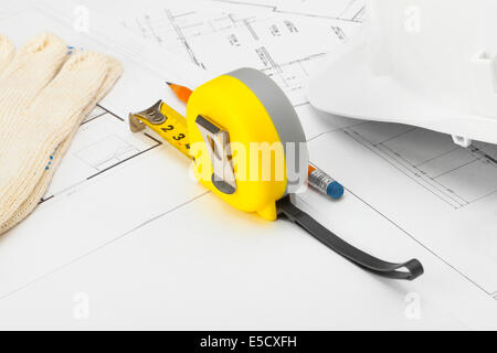 Mesurer avec bande jaune casque de construction et un crayon au-dessus de plan directeur Banque D'Images