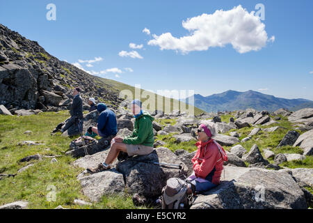 Les promeneurs randonneurs reposant sur des roches sur Moel Siabod avec vue de Snowdon en montagnes de Snowdonia National Park au nord du Pays de Galles Conwy UK Banque D'Images