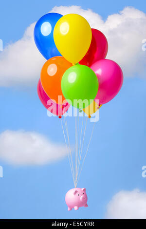 Tirelire volant dans le ciel sur des ballons d'hélium, bonne image des finances thèmes connexes tels que l'inflation, l'épargne ou d'économie. Banque D'Images