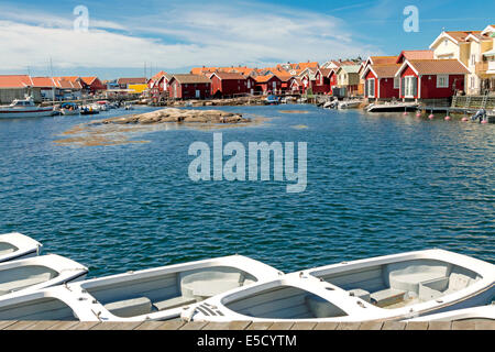 Cabanes de pêcheurs traditionnels colorés et les hangars à bateaux avec des bateaux le long de la jetée en bois à Smögen, Bohuslän, Suède, Scandinavie. Banque D'Images