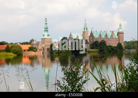 Château de Frederiksborg à Hillerød, en Zélande du Nord, au Danemark, vu de l'autre rive du lac du Château. Super saule-herbe dans le foyer. Banque D'Images