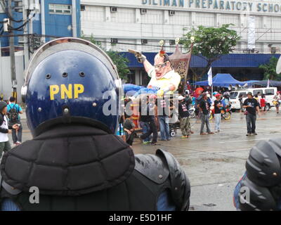 Quezon City, Philippines. 28 juillet, 2014. Sur la cinquième année du président Benigno "Noynoy" Aquino sur l'état de la Nation (SONA), des milliers de mécontents des groupes militants sur sa performance en tant que président ont marché vers Batasang Pambansa (Chambre du Congrès) dans la ville de Quezon avec leurs pancartes - tenue d'Aquino responsables de pillage des P144 milliards de dollars du Programme d'accélération des versements (DAP) - fonds et effigie de Aquino comme 'king' de l'assiette au beurre. 10 000 policiers ont été éliminés de la ville afin d'assurer l'ordre. Sherbien Dacalanio : Crédit / Alamy Live News Banque D'Images