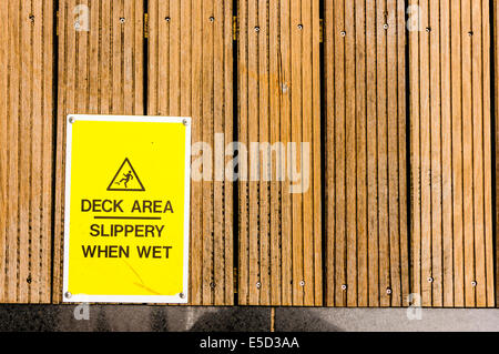Warning sign on decking en bois 'DEck' Zone humide lorsque Slipper Banque D'Images
