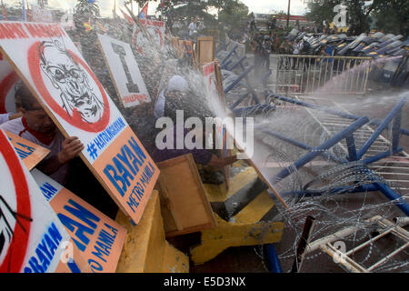 Quezon City, Philippines. 28 juillet, 2014. Les militants se dispersent la police avec des canons à eau au cours d'un meeting de protestation à Quezon City, Philippines, le 28 juillet 2014. Les manifestants se sont rassemblés pour montrer leur consternation sur diverses politiques du gouvernement alors que le Président Benigno Aquino III a prononcé son discours sur l'état de la Nation à la Chambre des représentants des Philippines. Credit : Rouelle Umali/Xinhua/Alamy Live News Banque D'Images