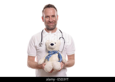 Friendly smiling middle-aged male pediatrician with chaumes non rasé holding a teddy bear avec un bras bandé de rassurer patient Banque D'Images