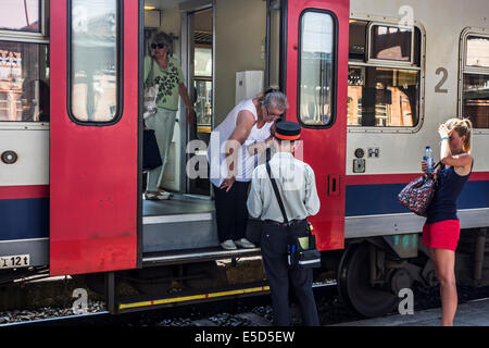 Femmes âgées demandent à l'information des passagers de l'employé de chemin de fer / ticket inspecteur de train sur plate-forme en railroad station Banque D'Images