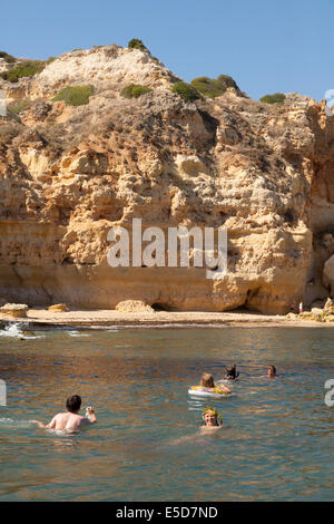 La natation de personnes dans l'océan Atlantique au large de la côte du Portugal au Praia da Marinha Marinha beach ( ), Algarve, Portugal Europe Banque D'Images