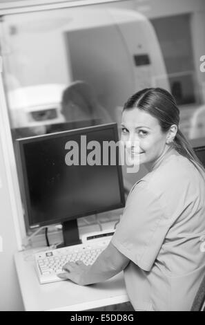 Young female doctor smiling travaillant sur le moniteur de machine irm scanner. Banque D'Images