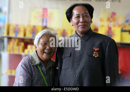 Kun Ming, Yun Nan, CHN. 26 juillet, 2014. KUNMING, CHINE - 26 juil 2014 ï¼šAn vieille femme a pris une photo avec le président Mao, typecast acteur. La 49e Newdrugs Chine, Chine Drug Store Show 2014 et 2014 MEDTEC sont détenus pendant 27 Juil 2014 à Kun Ming, la province de Yun Nan, Chine. L'un de l'exposant a invité le président Mao's typecast, acteur principal de la promotion des ventes. © SIPA Asie/ZUMA/Alamy Fil Live News Banque D'Images