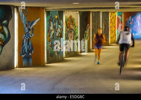 Passage inférieur pour piétons avec l'art du graffiti, avec une cycliste et un joggeur, Maximilian Park, Munich, Haute-Bavière, Bavière, Allemagne Banque D'Images