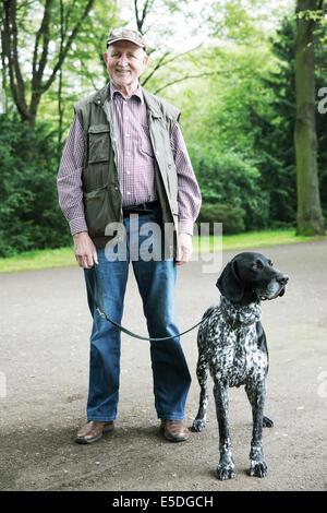 Hauts homme marchant avec son Braque allemand à city park Banque D'Images