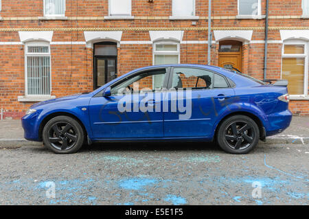 Belfast, Irlande du Nord. 29 juillet, 2014. Une voiture a été détruite par ses fenêtres ayant brisé, 'GET OUT' écrit sur elle et de la peinture jetée sur elle comme les maisons des familles étrangères ont été attaqués et des fenêtres brisées sur les maisons. Crédit : Stephen Barnes/Alamy Live News Banque D'Images