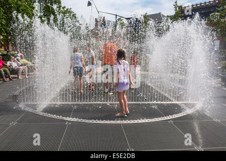 Amsterdam, Hollande, touristes enfants se rafraîchissant dans les fontaines de jardin publiques pendant la vague de chaleur estivale, ville de vague de chaleur Banque D'Images