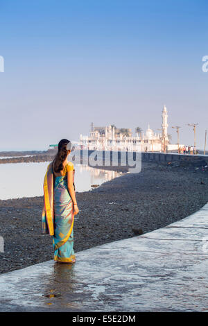 Une jeune femme hindoue dans un saree bleu sur la chaussée à la mosquée Haji Ali, Mumbai, Maharashtra, Inde Banque D'Images