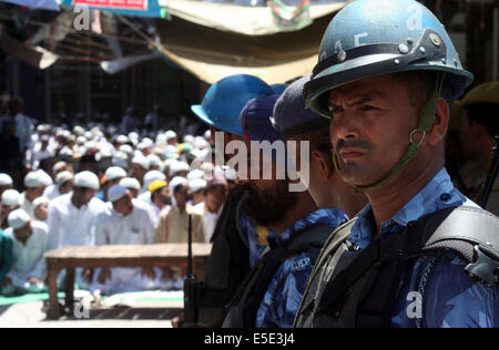 Varanasi, Inde. 29 juillet, 2014. Monter la garde de la police en tant que musulmans offrir des prières au cours de l'Eid al-Fitr sur une route à Varanasi, Inde, le 29 juillet 2014. Des millions de musulmans à travers le monde entier ont célébré l'Aïd al-Fitr, qui marque la fin du mois de jeûne du Ramadan. Credit : Stringer/Xinhua/Alamy Live News Banque D'Images